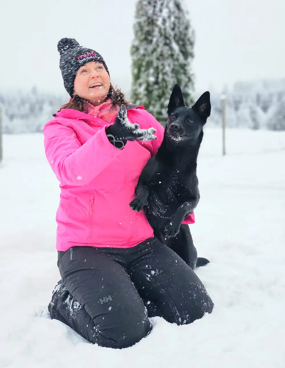 Murumedian Mari ja koira leikkivät lumella
